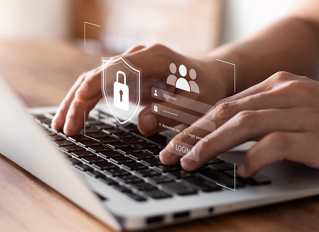 Cybersecurity Training - Closeup View of Person Typing on a Laptop with a Login Screen Graphic Overlay on Top in Cybersecurity Concept