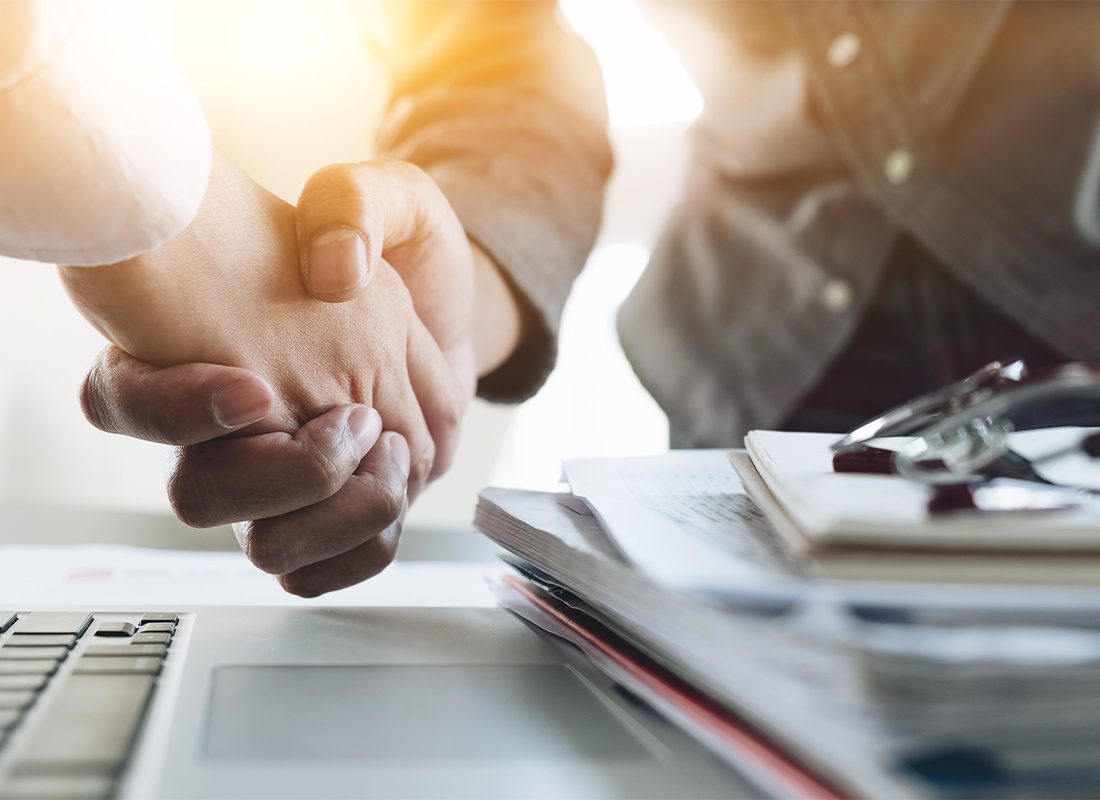 Heritage Insurance Group and Pillar Associates - Two People Shaking Hands After an Acquisition